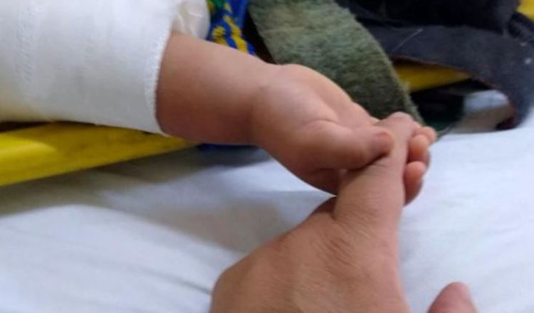 Imaginea care a emoționat internetul. Un bebeluș, rămas orfan în urma unui accident, strânge mâna paramedicului care l-a salvat