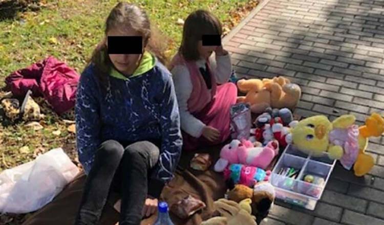 Două fetițe își vând jucăriile plângând, pe o stradă din Roman, pentru ca părinții să achite facturile